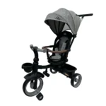 Triciclo Flex Baby Cam gris con capota, manija de empuje, asiento acolchado y canastilla, ideal para paseos seguros del bebé.