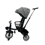 Triciclo Flex Baby Cam gris con capota, manija de empuje, asiento acolchado y canastilla, ideal para paseos seguros del bebé.