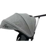 Triciclo Flex Baby Cam gris con capota, manija de empuje, asiento acolchado y canastilla, ideal para paseos seguros del bebé.