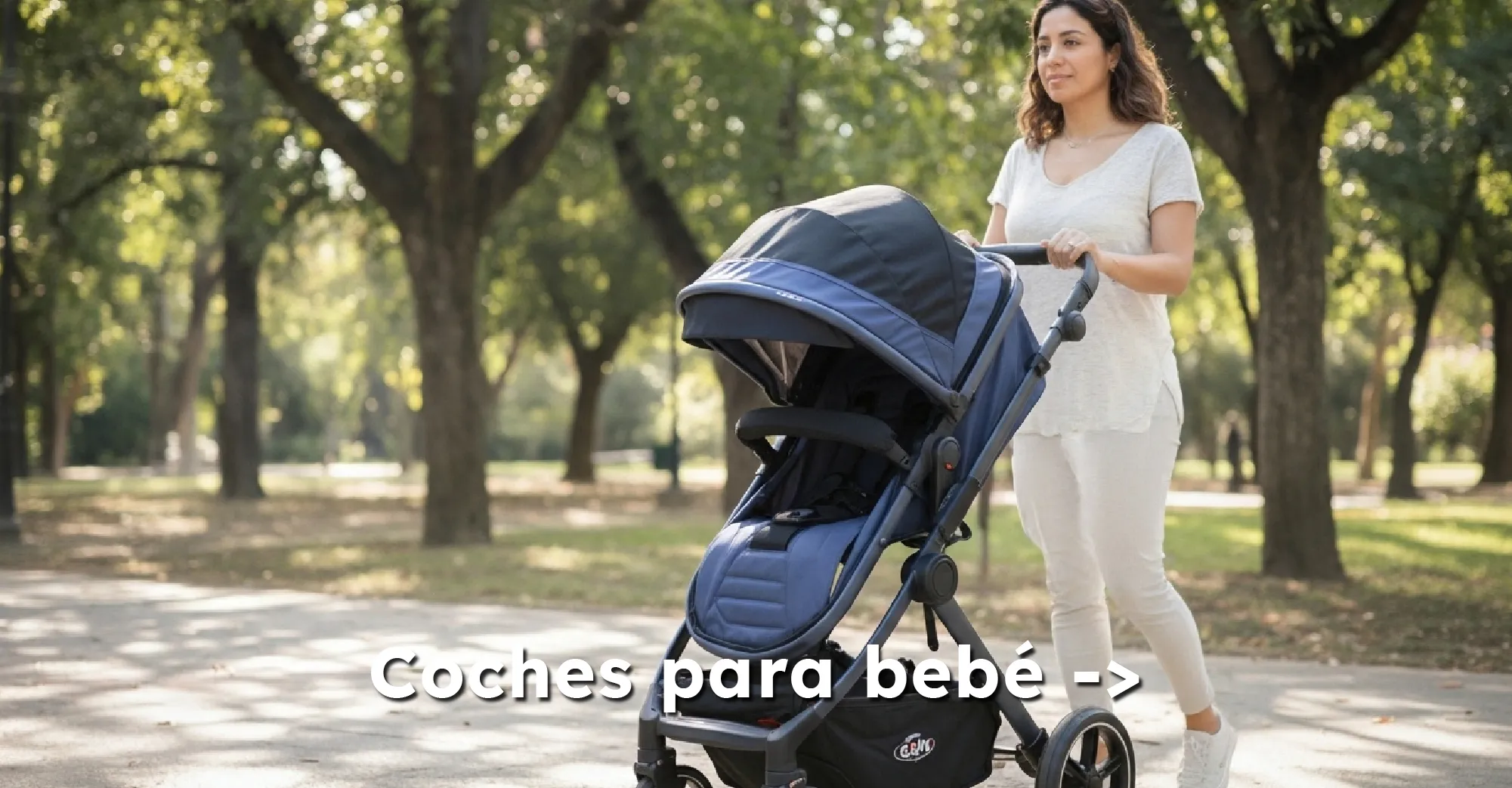 Mamá paseando a su bebé en coche azul oscuro por un parque lleno de árboles